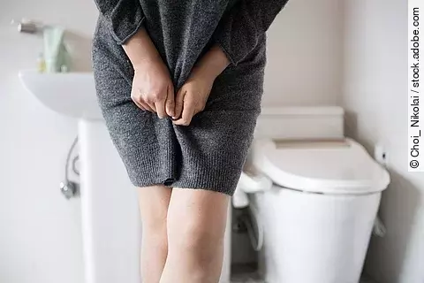 A woman wearing knitwear is complaining of pain from urinary inc
