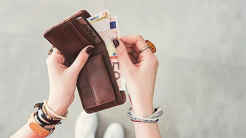 Woman taking out euro money from her pocket wallet top view Portemonnaie; Strafe für Arzttermin-Schwänzer gefordert