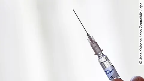 Grippeschutzimpfung - eine Hand hält eine Spritze zur intramuskulären Injektion des Impfstoffs Grippeschutzimpfung - eine Hand hält eine Spritze zur intramuskulären Injektion des Impfstoffs