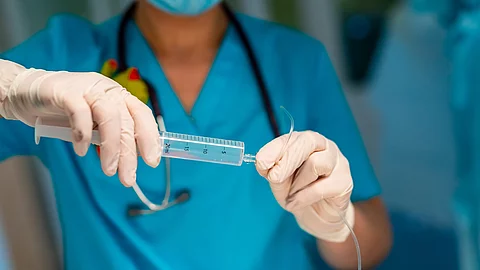 Doctor adjusts medical dropper with medicine in surgery room. Selective focus on hands.