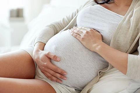 close up of pregnant woman lying in bed at home