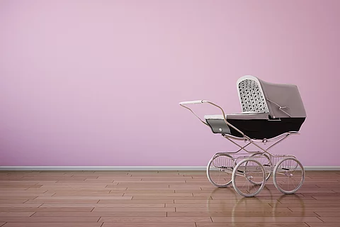 Baby stroller on pink wall horizontal