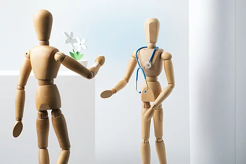 Arzt und Patient als Holzfigur