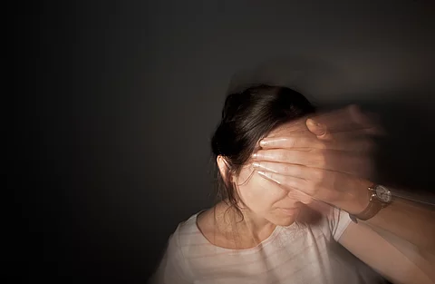 Eine Frau fasst sich mit der Hand an die Stirn: ein Anzeichen für starke Migränekopfchmerzen