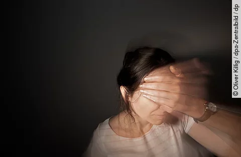 Eine Frau fasst sich mit der Hand an die Stirn: ein Anzeichen für starke Migränekopfchmerzen