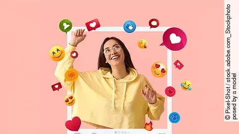 Happy young female blogger on pink background