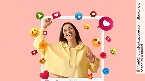 Happy young female blogger on pink background