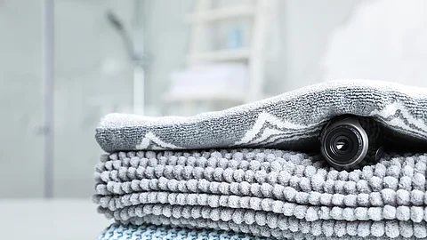 Camera hidden under towel in bathroom, closeup Camera hidden under towel in bathroom, closeup