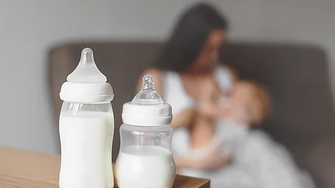 Bottles with breast milk on the background of mother holding in Bottles with breast milk on the background of mother holding in