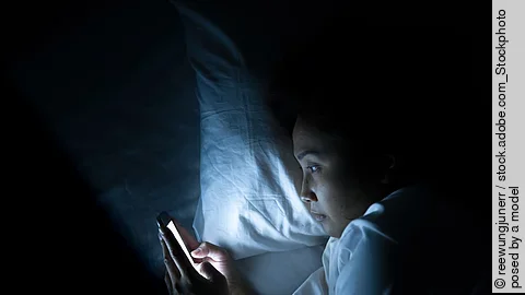 Asian woman play smartphone in the bed at night,Thailand people