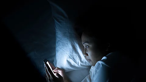 Asian woman play smartphone in the bed at night,Thailand people