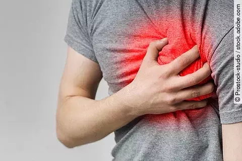 Mann hält sich linke Brust, die rot leuchtet