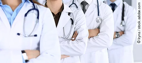 Group of modern doctors standing as a team with arms crossed in