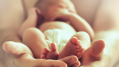 Neugeborenes in den Händen seiner Mutter