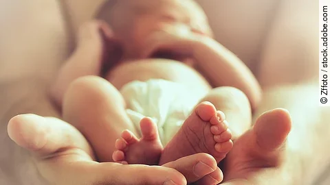 Neugeborenes in den Händen seiner Mutter