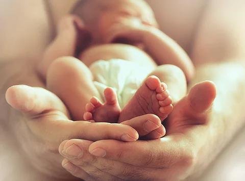 Neugeborenes in den Händen seiner Mutter
