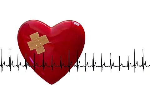 rotes Herz mit Pflaster und EKG, weißer Hintergrund