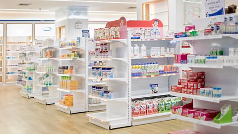Medicines arranged in shelves, Pharmacy drugstore retail Interior blur abstract background with medicine healthcare product on glass cabinet with neon light.