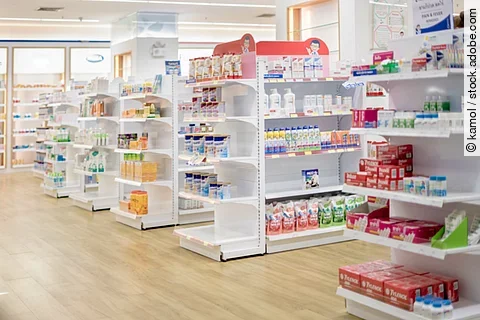 Medicines arranged in shelves, Pharmacy drugstore retail Interior blur abstract background with medicine healthcare product on glass cabinet with neon light.