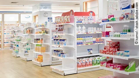 Medicines arranged in shelves, Pharmacy drugstore retail Interior blur abstract background with medicine healthcare product on glass cabinet with neon light.