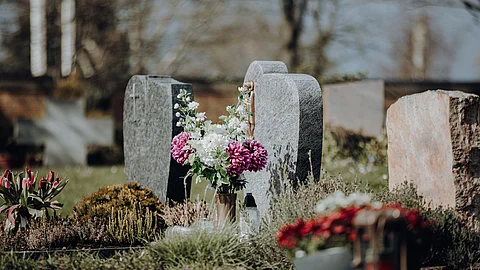 grave stone with flowers at graveyard