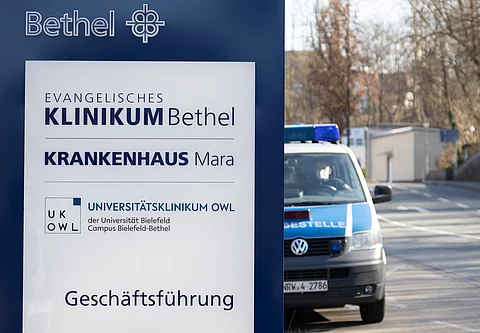 Ein Fahrzeug der Polizei steht an einem Gebäude der Geschäftsführung des Evangelischen Klinikums Bethel.