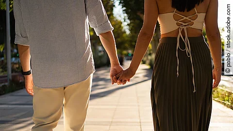 Pärchen hält Händchen beim Spazierengehen