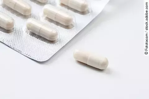 Pile of white capsules probiotic powder inside. Copy space. High