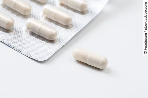 Pile of white capsules probiotic powder inside. Copy space. High