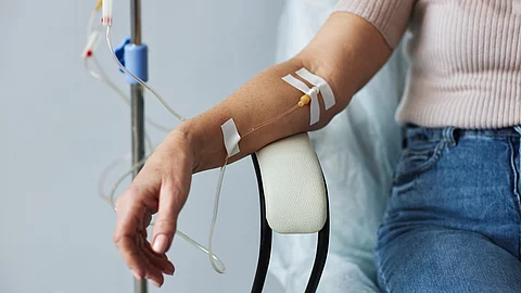 Frauenhand mit Infusionsschlauch während einer Behandlungssitzung