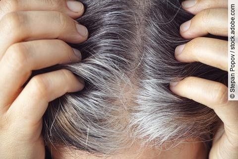 A woman showing her gray hair roots