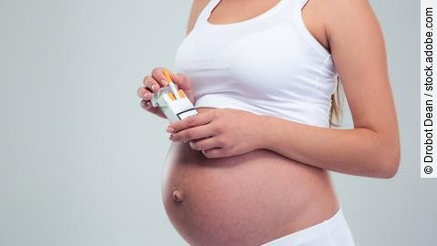 Pregnant woman holding cigarettes